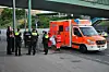 Ein Mann mit nacktem Oberkörper steht neben einem Rettungswagen