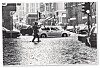 Um 1990 steht die Poststraße unter Wasser. Ein Passant trägt einen Kinderwagen und watet Richtung Große Bleichen.