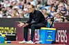Thomas Tuchel sitzt vor einer Werbebande