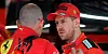 Sebastian Vettel bespricht mit einem Ingenieur die Probleme an seinem Ferrari.