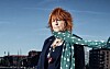Maggie Reilly: rote Haare, grüner Schal mit weißen Punkten