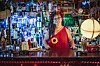 Frau im roten Kleid mit schwarzen Haaren hinter Kneipentresen