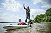 Mann steht auf seinem SUP auf der Elbe am Strand