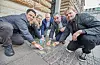 Die Abgeordneten Deniz Celik (Linke), Vanessa Mohnke (SPD), Dennis Thering (CDU), Danial Ilkhanipour (SPD) und Michael Gwosdz (Grüne, v.l.), reinigen Stolpersteine vor dem Rathaus.