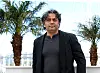 Rassulof steht bei einem Photocall für das Filmfestival in Cannes, hinter ihm Palmen