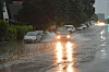 Auto fährt durch Regenwasser auf der Straße