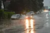 Auto fährt durch Regenwasser auf der Straße