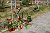 Blumen liegen am Tatort. Nach dem gewaltsamen Tod ermittelt die Polizei wegen Mordes.
