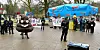 Polizisten und Demonstranten vor dem AfD-Stand in Volksdorf – und ein tanzender Kackhaufen.