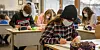 Schülerinnen und Schüler tragen während des Unterrichts medizinischen Mund-Nasen-Schutz.