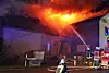 Feuerwehrleute löschen das brennende Dach.