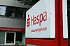 Haspa-Logo an einer Filiale mit rotem Schilderrahmen vor einem Bankgebäude.