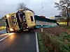 Ein Lkw liegt umgekippt auf der Straße, Tausende Kartoffeln sind auf dem Feld neben der Straße gelandet.