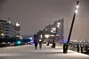 Passanten gegen über einen schneebedeckten Fußweg, im Hintergrund die Elbphilharmonie Hamburg.