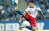 Ludovit Reis streichelt in der Luft mit dem Fuß den Ball.