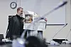Die Angeklagte verbirgt sich hinter einer Zeitung, neben ihr steht ihr Anwalt Martin Heising