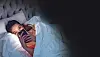 Eine Frau liegt mit Handy im bett