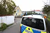 Ein Polizeiauto steht vor einem Wohnhaus im Ort.