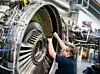 Ein Mann arbeitet in einer Werkstatt von Lufthansa Technik am Triebwerk eines Flugzeuges. (Symbolfoto)