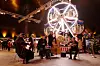 Im Inneren des Zirkuszeltes, hinten ein kleines Riesenrad, vorne eine Band