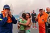 Menschen blicken entsetzt und halten sich im Arm