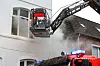 Drehleiter vor qualmendem Fenster