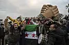 Feiernde Menschen mit syrischer Flagge