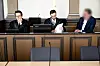 Der Angeklagte (r.) sitzt vor Prozessbeginn mit seinen Anwälten Viktor Volkmann (l) und Sebastian Vogel im Gerichtssaal.