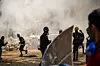 Protestierende vor den Trümmern einer Barrikade.