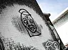Das One-Line-Graffiti auf einer weiß bemalten Hauswand.
