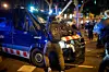 Ein Demonstrant schlägt auf ein Polizeiauto ein.