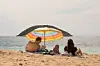 Eine Familie liegt am Strand auf Mallorca.