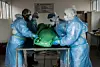 Südafrika: Bestatter in Schutzkleidung