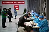 In China füllen Einwohner vor der Corona-Impfung Formulare aus.