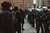 Demonstranten und Polizeibeamte stehen vor dem Gerichtsgebäude.