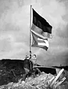 Die beiden Studenten hissen die Europa- und die deutsche Flagge