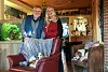 Gerd (70) und Heike (68) Spiekermann mit einer der Katzen und den beiden Hunden vor dem Aquarium. Die Tiere sind essentiell für die Pflegekinder, sagen die Bereitschaftspflegeeltern.