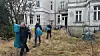 Polizisten bringen Beweismittel aus der alten Villa in Lübeck nach draußen.