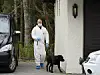 Ein Beamter mit Spürhund sucht am Haus der Hagens nach Indizien.