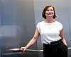 Kathrin Baumstark steht lächelnd in einem Fahrstuhl