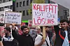 Männer halten Schilder hoch: „Das Kalifat ist die Lösung“