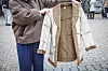 Eine beige Jacke mit braunen Teddy-Fell-Details wird in die Kamera gehalten.
