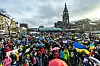 Vor dem Hauptbahnhof stehen zahlreiche Menschen und halten Ukraine-Flaggen hoch