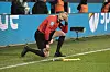 Schiedsrichter-Assistent Christian Gittelmann kniet nach einem Becherwurf an den Kopf auf dem Rasen.