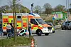 Vor einem Rettungswagen steht eine Familie mit Kinderwagen