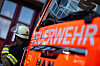 Ein Feuerwehrmann steht neben einem Feuerwehrauto.