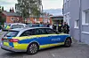 Ein Polizeiwagen und mehrere Einsatzkräfte vor einem Haus