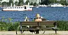 Frau sitzt im Sommer in Hamburg auf Parkbank