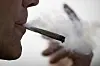 Ein Mann raucht einen Joint.