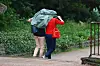 Zwei Frauen schützen sich mit einer Jacke vor dem Regen.